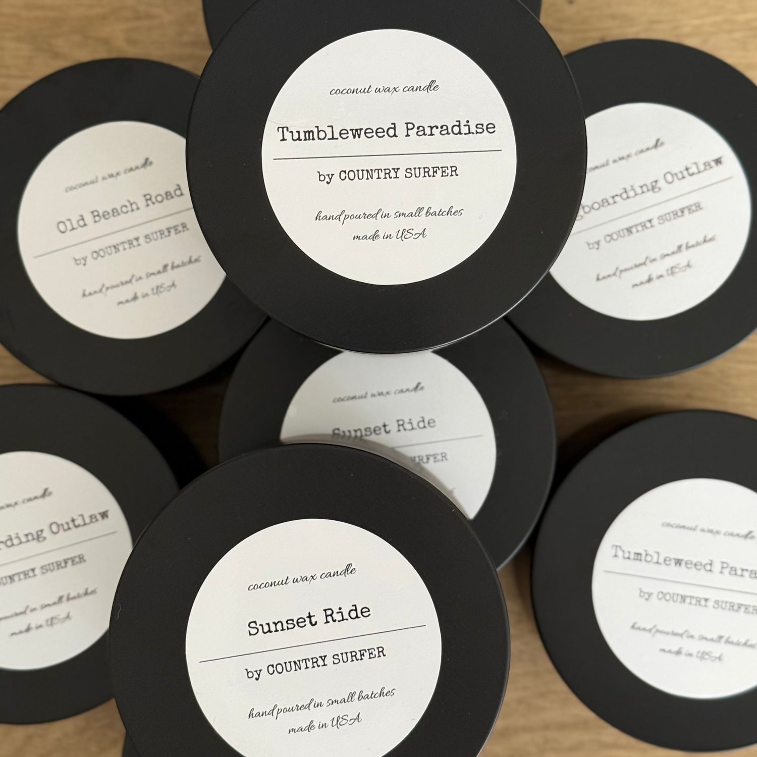 Collection of 8oz coconut wax candles with labels on a wooden surface