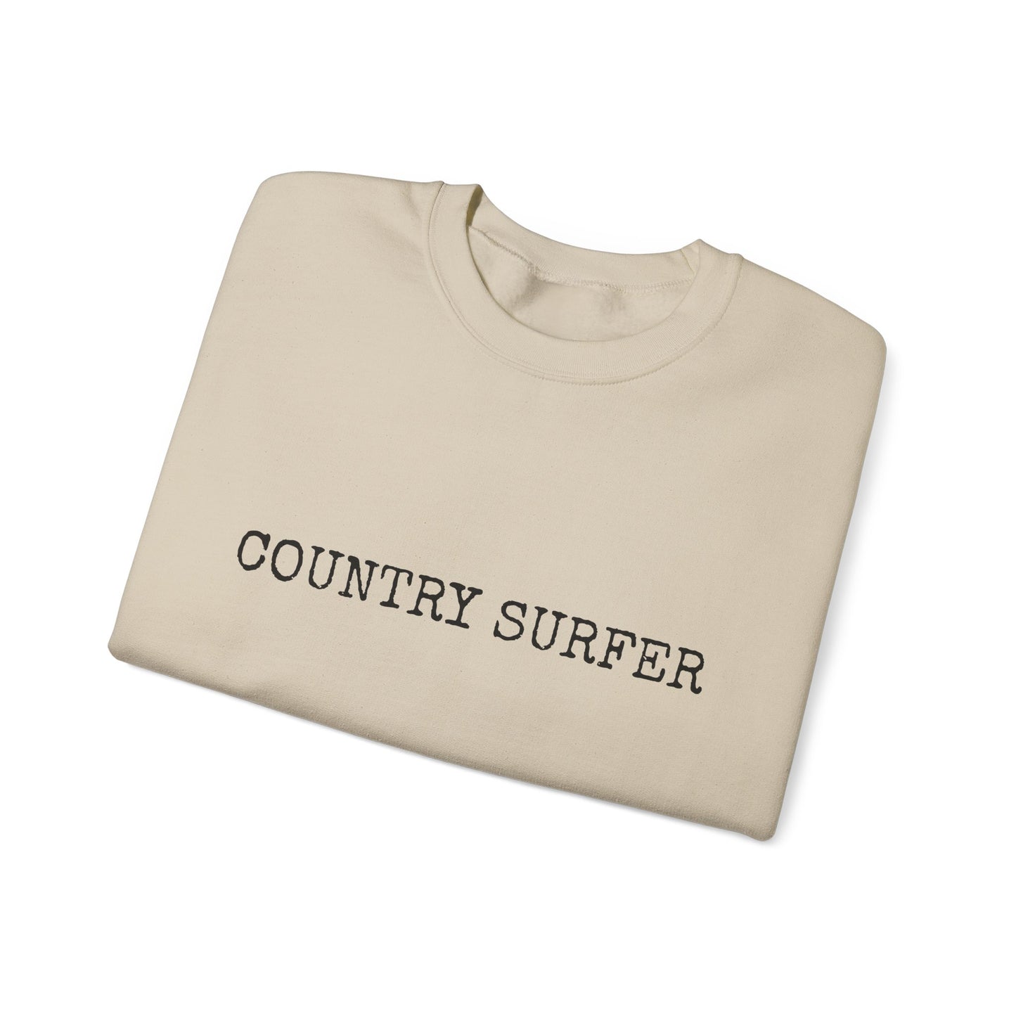 Folded beige sweatshirt with 'COUNTRY SURFER' text on a white background