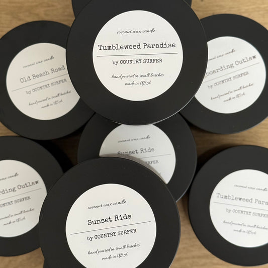 Collection of 8oz coconut wax candles with labels on a wooden surface